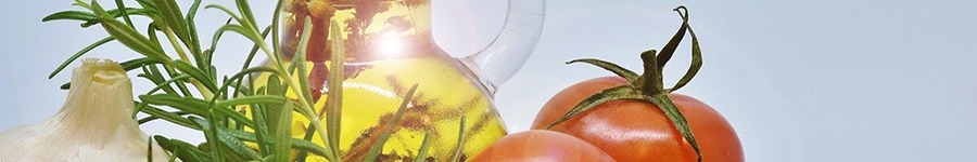 close up of an oil bottle with an onion and tomato