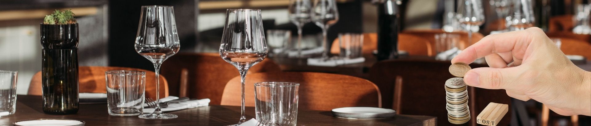 A hand counting money with a restaurant backdrop