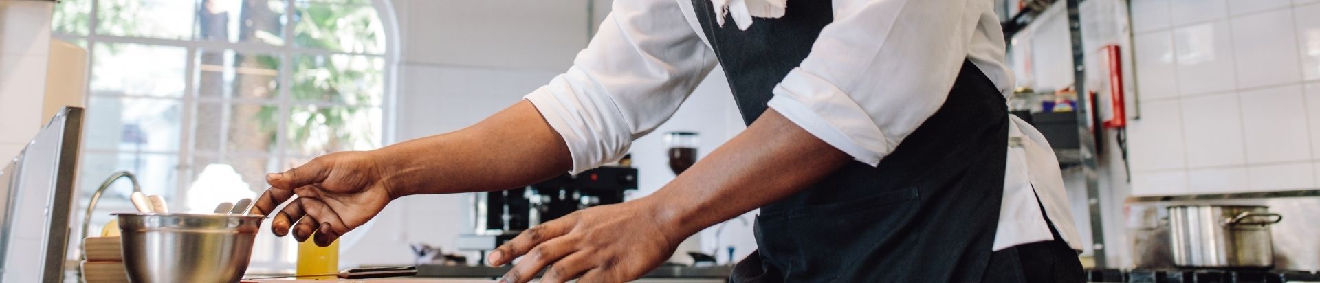 Chef reaching for food prep bowl