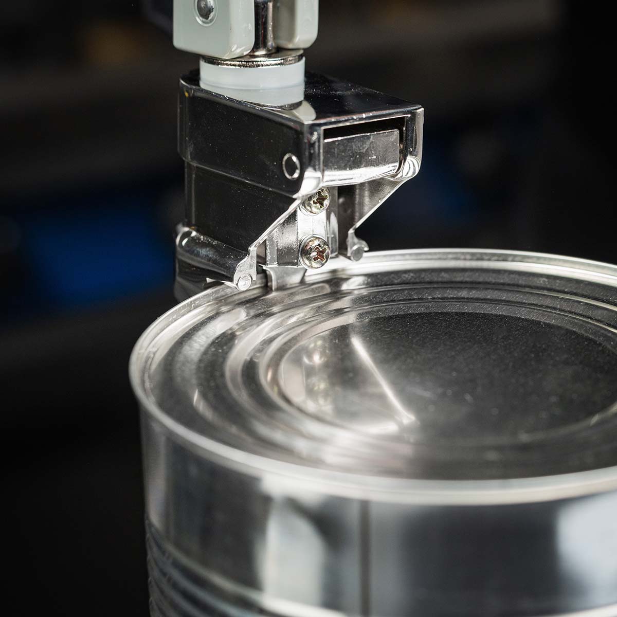 Close up of the tin opener piercing the top of the can
