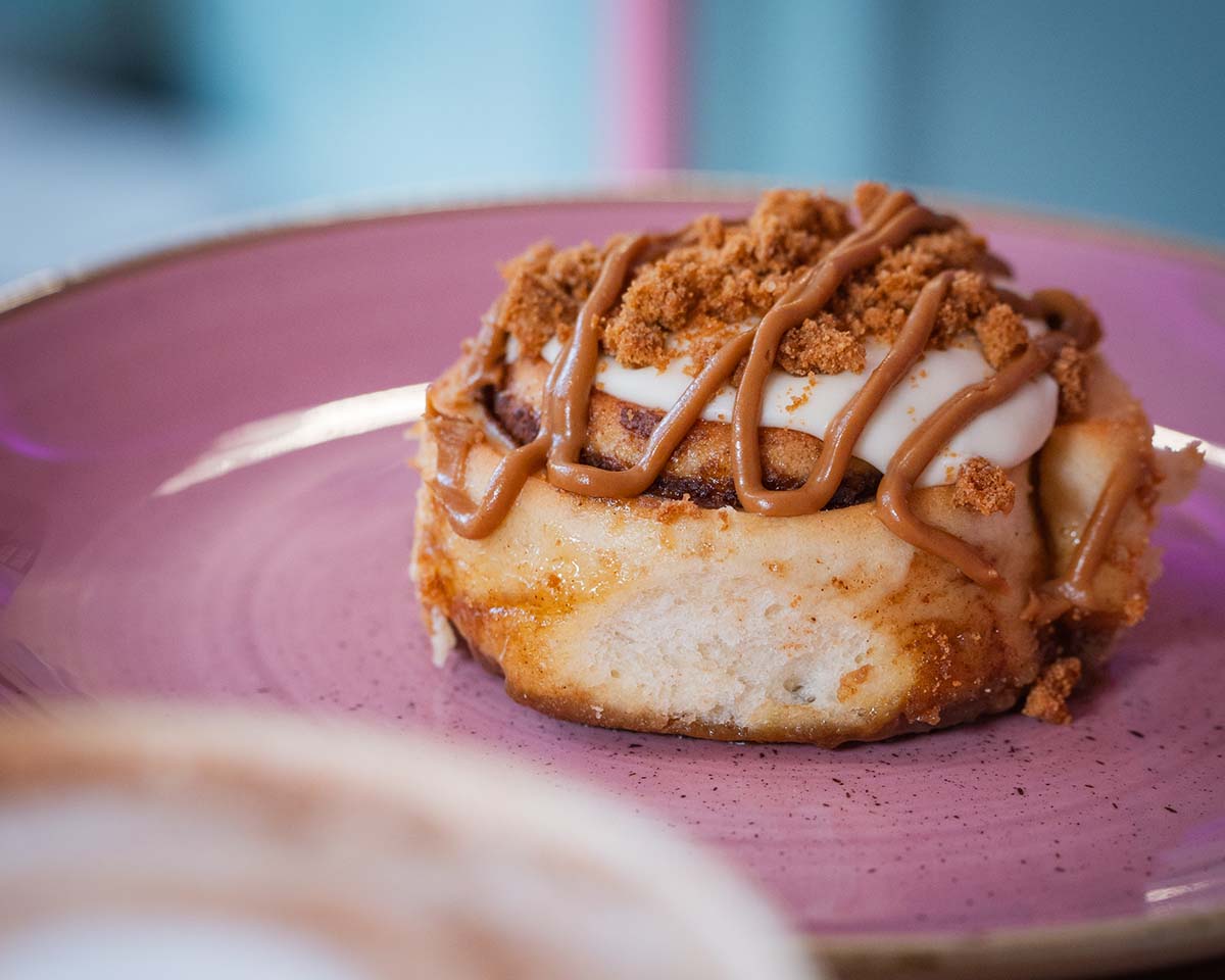 Cinnamon bun on a pastel pink plate