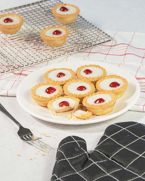 Bakewell tarts on a plate and a cooling rack