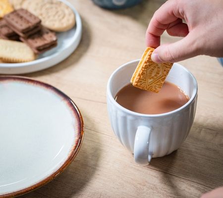 Dunking a biscuit into a cup of tea