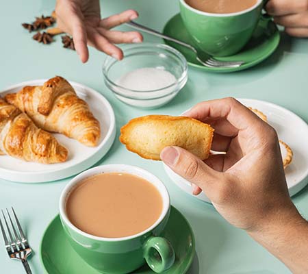 People sharing snacks over a cup of chai
