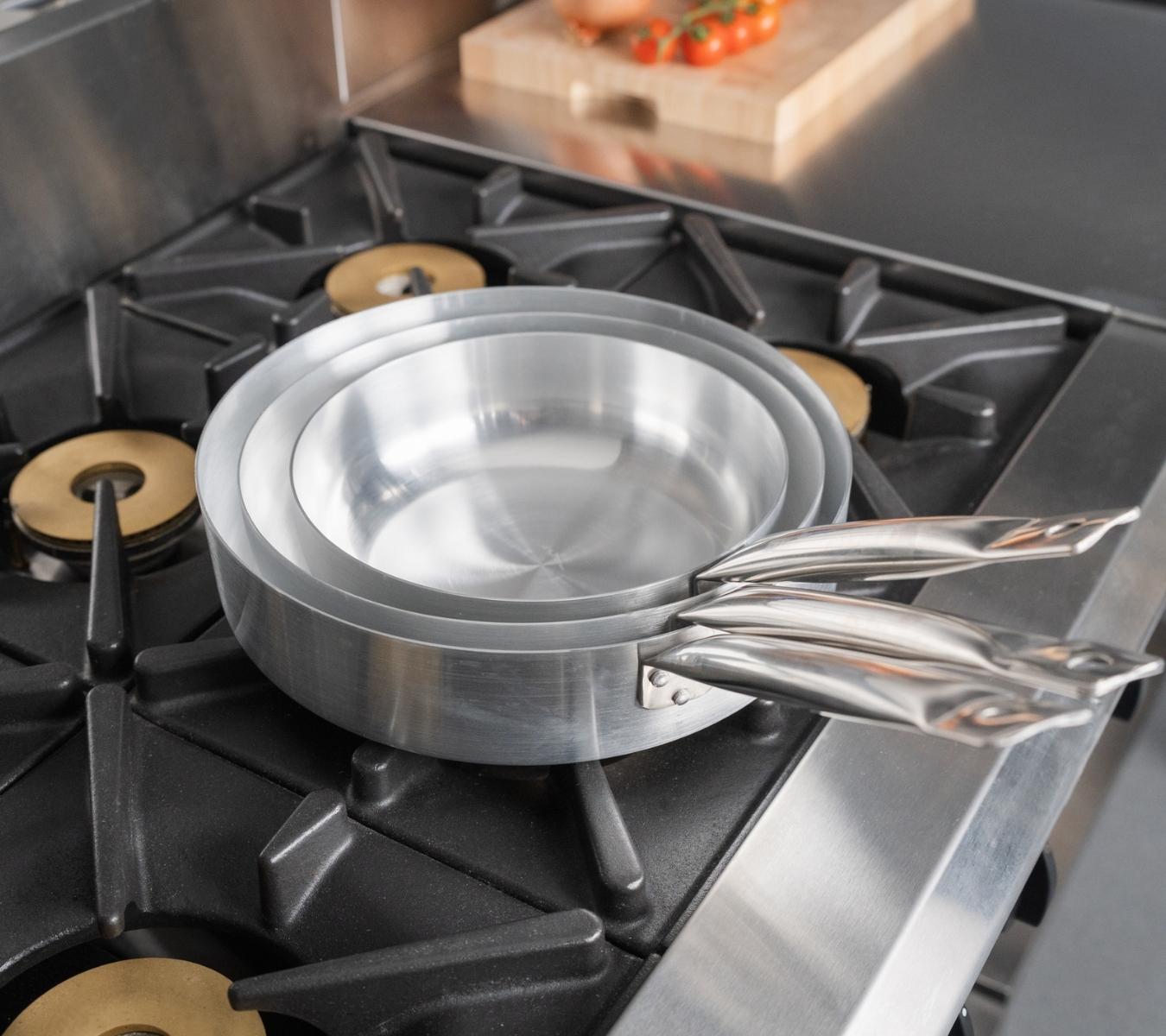 Aluminium frying pans on a gas burner range