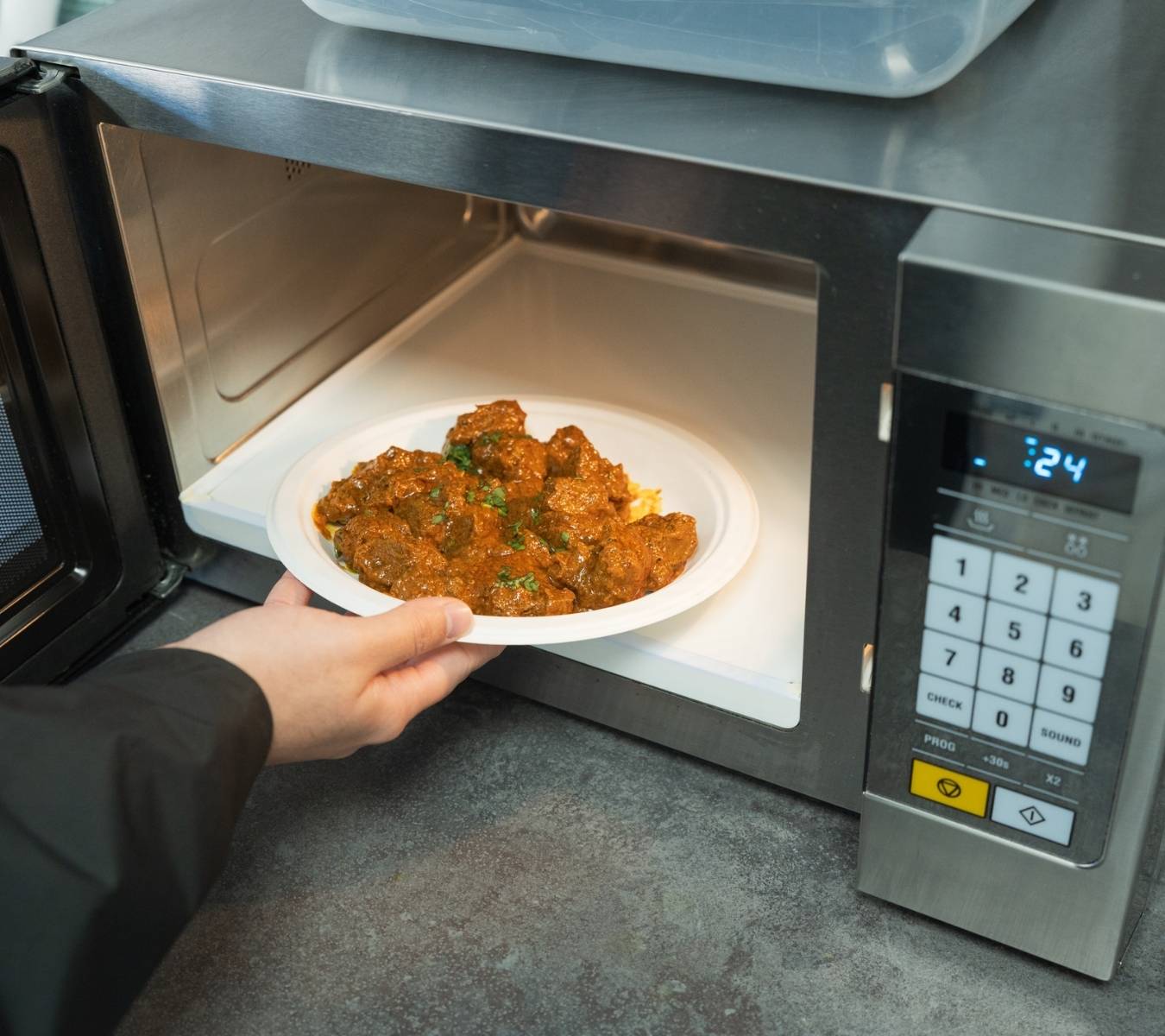 Bagasse plate going into a microwave