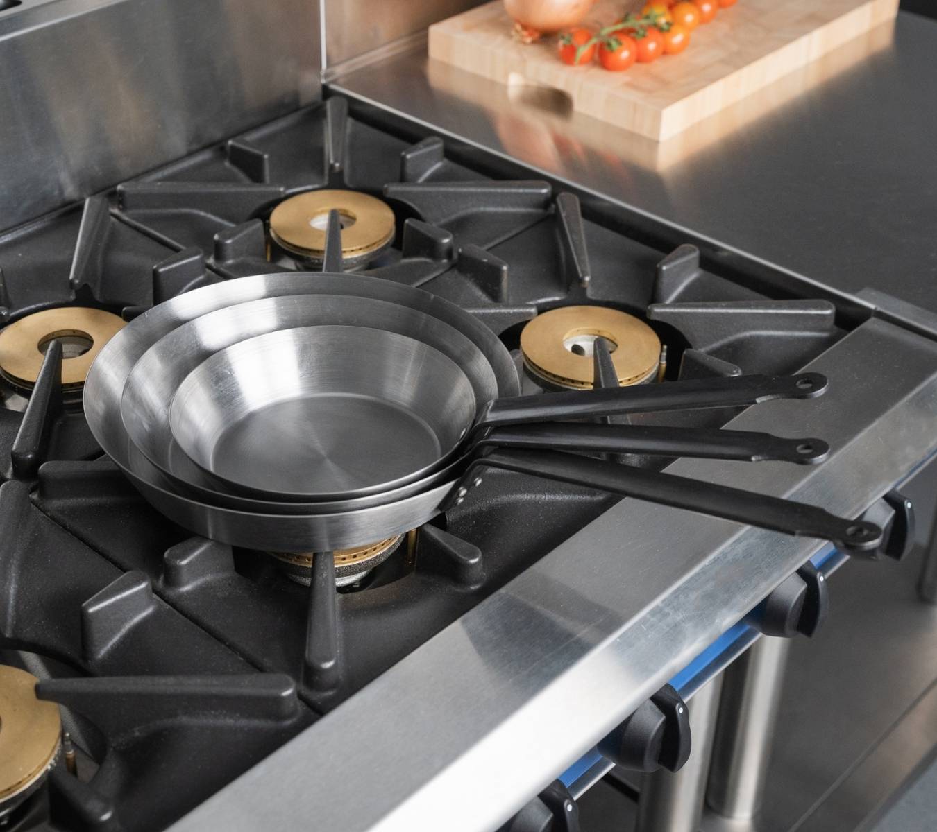 Black iron frying pans on a gas burner range