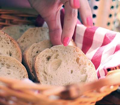 Fingers reaching into a bread basket