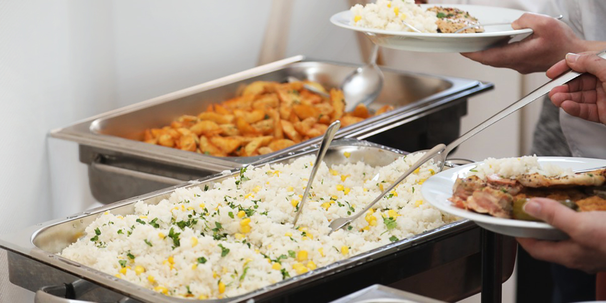 People getting food from a chafing dish