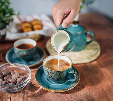 Pouring milk into a cup of chai