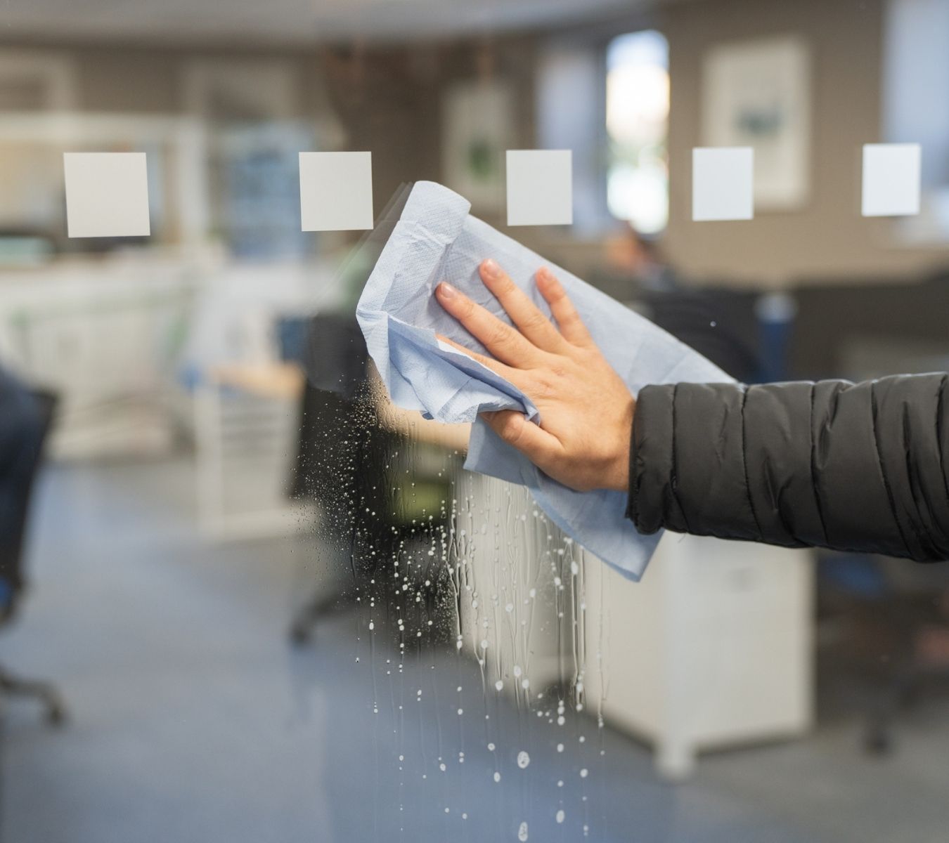 Cleaning a window with blue roll