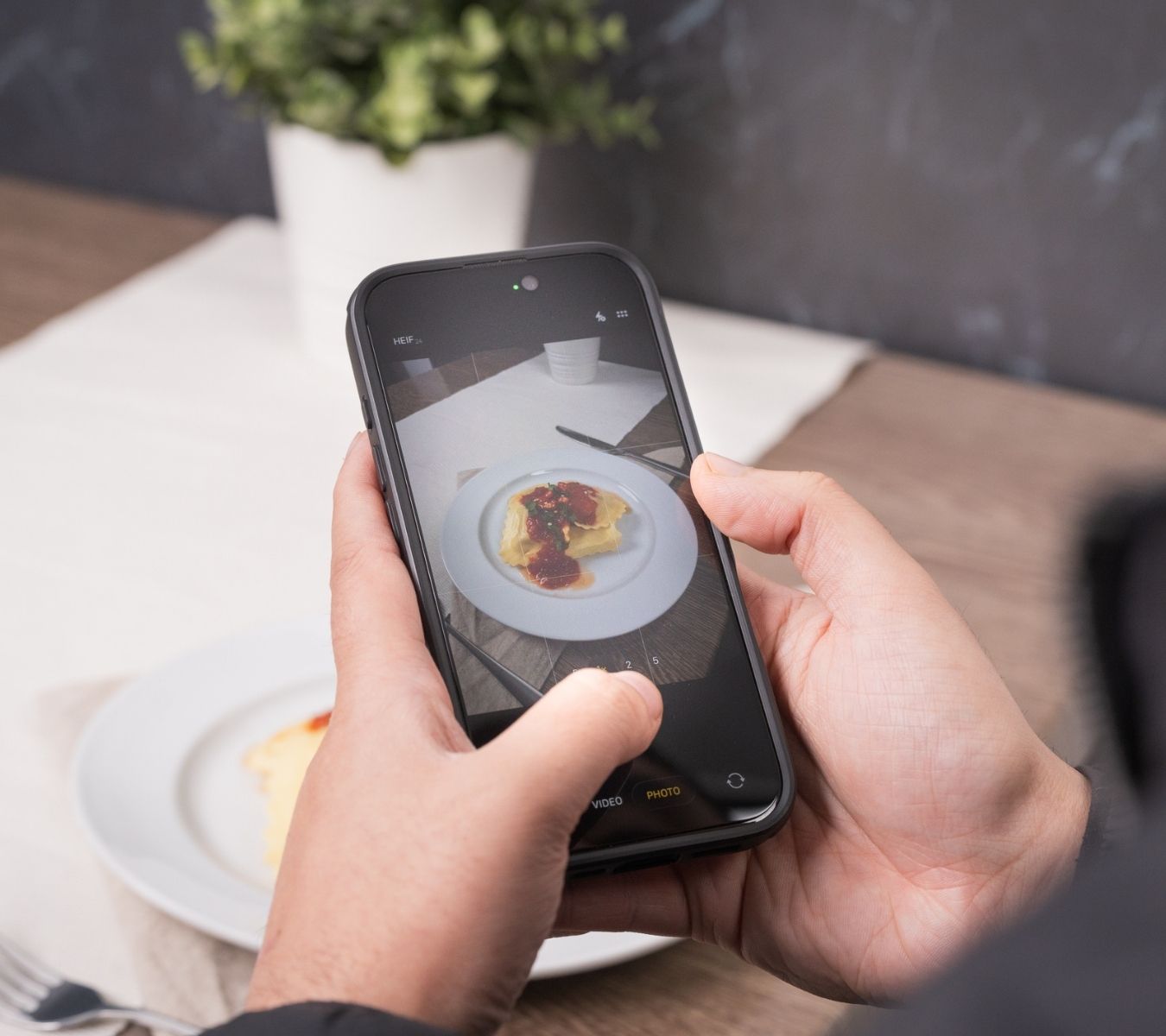 Person taking a picture of their food in a restaurant