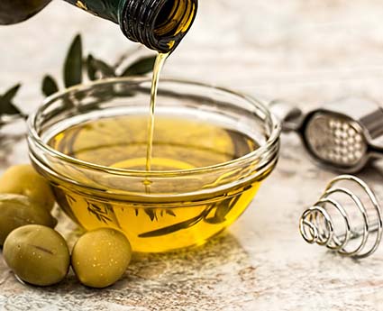 Olive oil pouring into a bowl