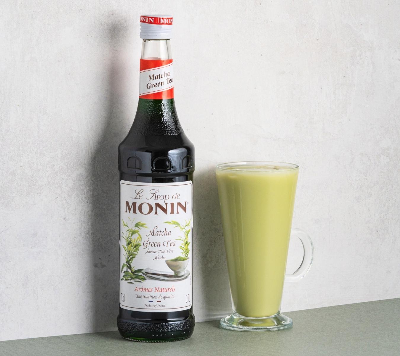 Matcha latte with bottle of Monin Match syrup
