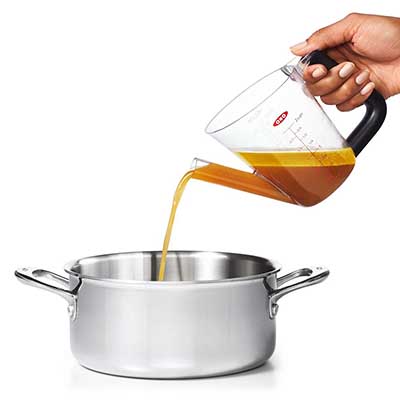 Pouring gravy into a pan with an Oxo gravy jug
