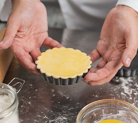 Pastry chef showing off an egg washed tart