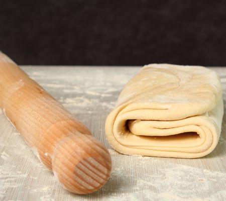 Folded puff pastry and a rolling pin