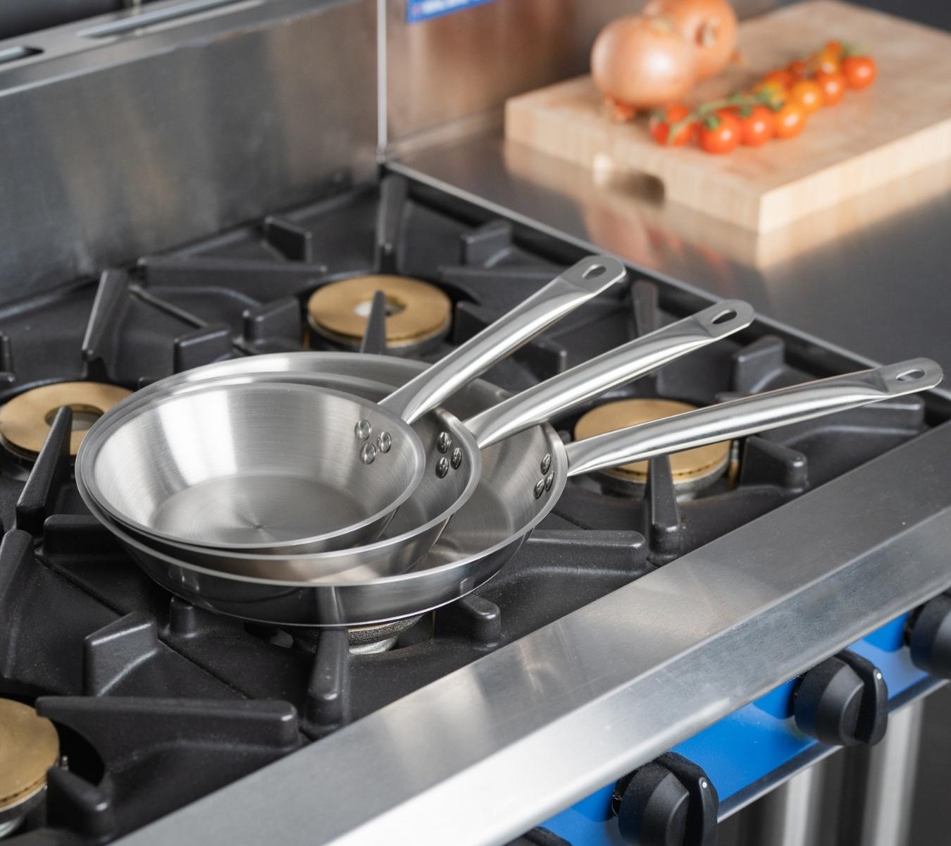Stainless steel frying pans on a gas burner